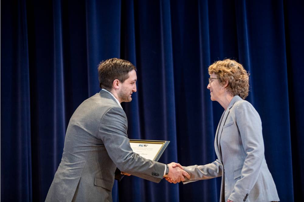 Tom Worm (left) giving Dr. Cathy Harro (right) her award.